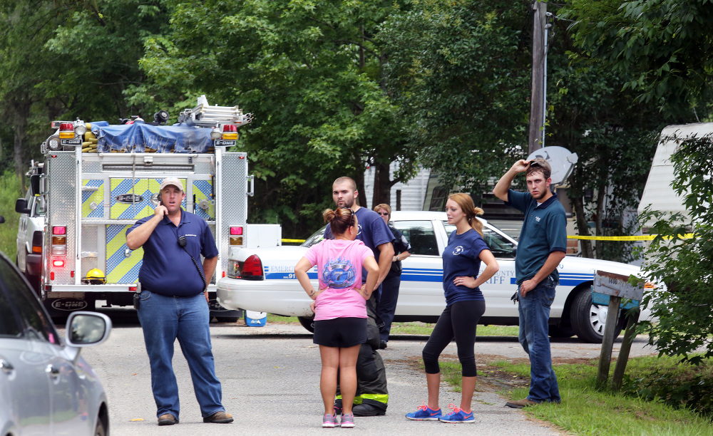 Emergency personnel stand outside a campground surrounded by police tape near Moncks Corner, S.C., on Tuesday, after an F-16 fighter jet smashed into a small plane.