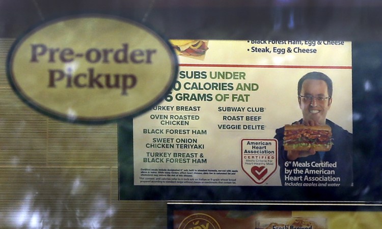 A photo of Subway restaurant spokesman Jared Fogle is seen on a menu board hanging inside one of its locations Tuesday in St. Louis.