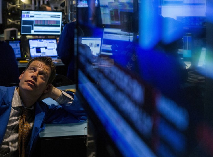 A trader watches a screen while waiting to see what has happened on the floor of the New York Stock Exchange after a malfunction halted trading for four hours on Wednesday.
