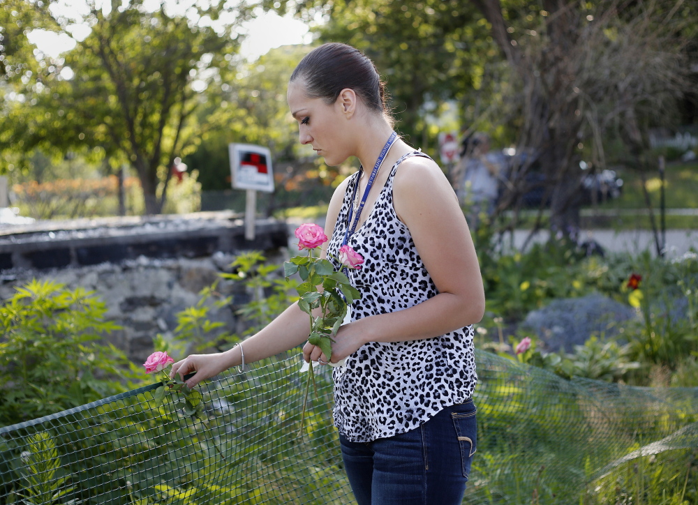 PORTLAND, ME - JULY 10: Ashley Summers, the wife of Steven Summers, one of the six victims who died in a fire in Portland on Nov. 1, 2014, lays flowers at the site of the fire on Noyes Street in Portland. The landlord of the building, Gregory Nisbet, was indicted on 6 counts of manslaughter on Friday, one for each of the victims of the state's deadliest fire in decades. (Photo by Derek Davis/Staff Photographer)