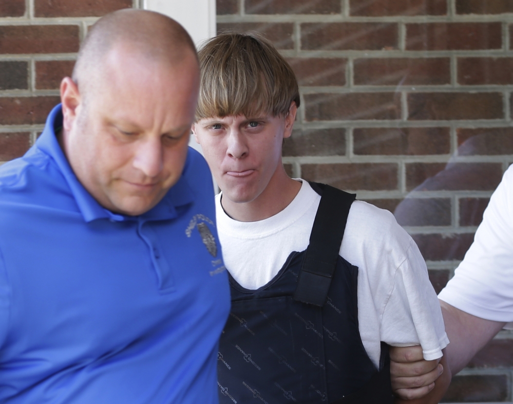 Charleston, S.C., shooting suspect Dylann Storm Roof, center, shown in June, never should have passed the background check that enabled him to buy a handgun, the FBI said.