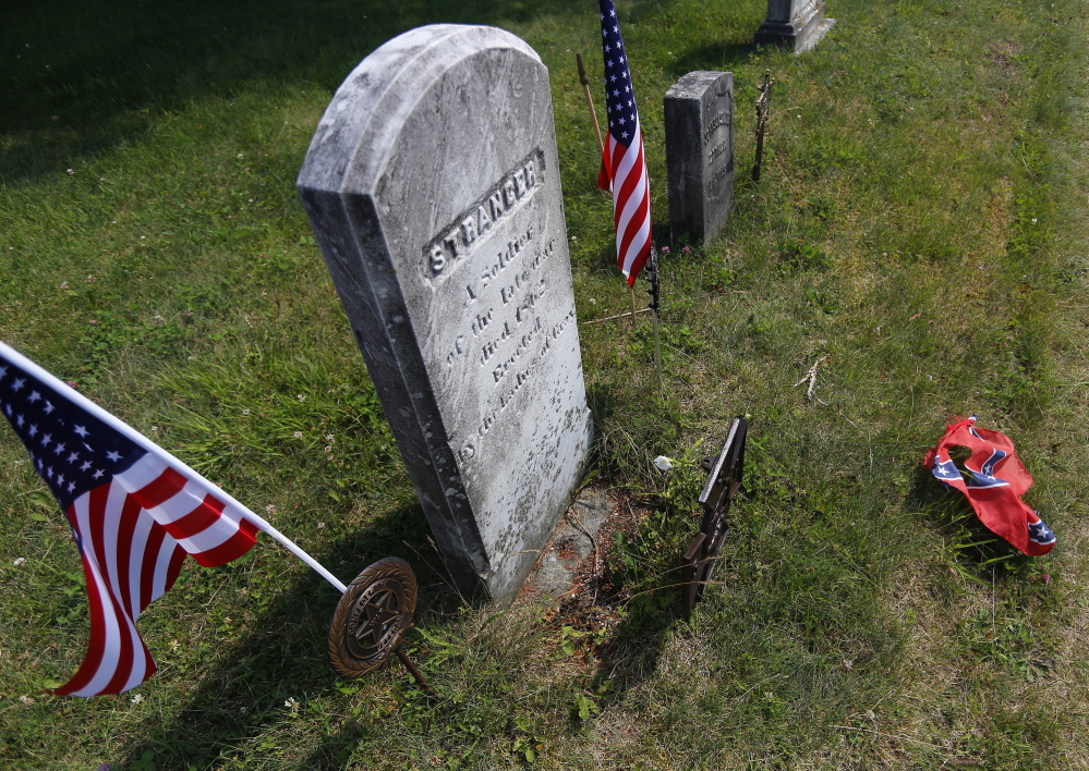 A Confederate flag that had decorated the grave of an unknown Confederate soldier in Gray lies on the ground Friday after being removed and replaced by two American flags.
Derek Davis/Staff Photographer