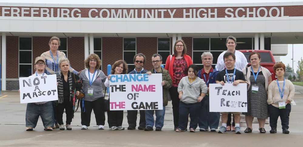 Members of the Little People of America pose outside of Freeburg High School while delivering superintendent Andrew Lehman a petition requesting that school change its nickname from the “Midgets” on Friday.