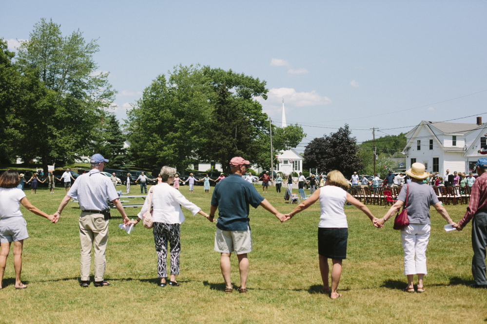 Attendees of the vigil for Jorgensen family gather in a circle and hold hands, as a symbol of unity and peace in Boothbay on Saturday. Whitney Hayward/Staff Photographer