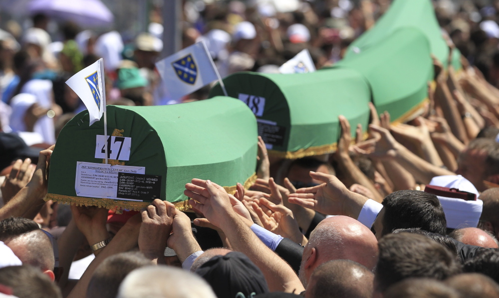 People carry coffins to graves at near Srebrenica, Bosnia and Herzegovina. The bodies of the 136 recently identified victims of the Srebrenica massacre were buried during ceremonies to mark the 20th anniversary of the massacre.