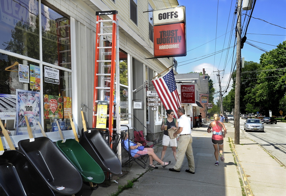 Several people chat in front of Goff’s Hardware on Main Street in Yarmouth. Once a busy retail district, Main Street has gotten quiet as the town’s business epicenter shifted to Route 1.