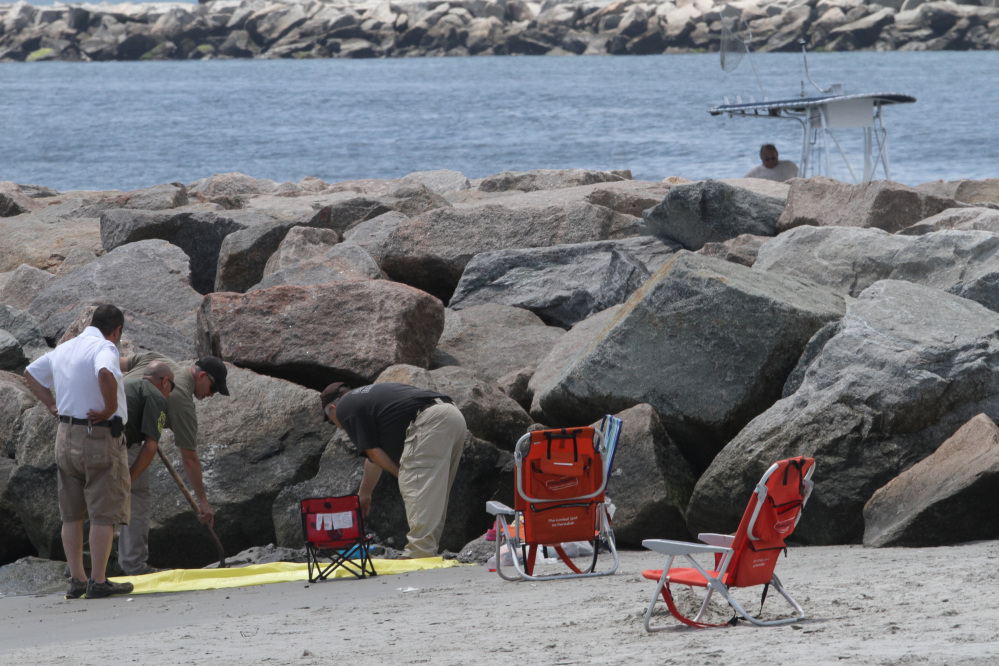Authorities investigate a mysterious blast that threw a beachgoer into a nearby jetty at Salty Brine beach in Narragansett, R.I., on Saturday. Gov. Gina Raimondo said Tuesday that investigators had ruled out any unlawful or malicious activity as the cause of the blast.