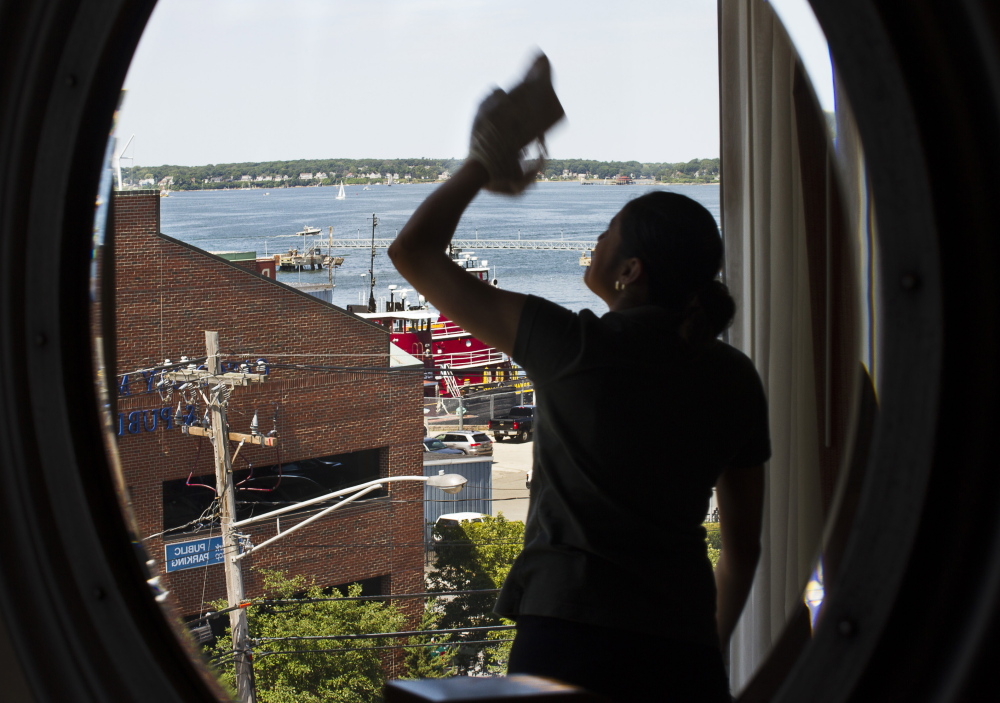 With the tall ships festival and other summer events going on this weekend, Hilton Garden Inn housekeeper Karen Gomez makes sure there’s a clear view of Casco Bay from a window Thursday.