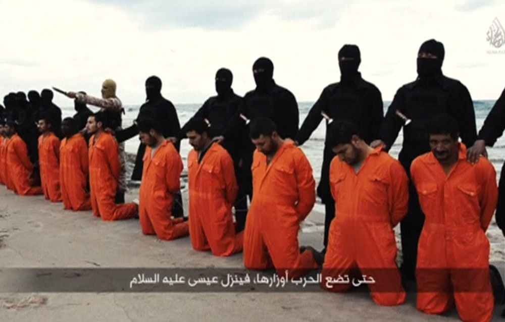 Copy Ed: Pls. try to focus on today’s news.......Men in orange jumpsuits purported to be Egyptian Christians held captive by the Islamic State (IS) kneel in front of armed men along a beach said to be near Tripoli, in this still image from an undated video made available on social media on February 15, 2015. Islamic State released the video on Sunday purporting to show the beheading of 21 Egyptian Christians kidnapped in Libya. In the video, militants in black marched the captives to a beach that the group said was near Tripoli. They were forced down onto their knees, then beheaded. Egypt’s state news agency MENA quoted the spokesman for the Coptic Church as confirming that 21 Egyptian Christians believed to be held by Islamic State were dead. REUTERS/Social media via Reuters TV (CIVIL UNREST CONFLICT TPX IMAGES OF THE DAY) ATTENTION EDITORS - THIS PICTURE WAS PROVIDED BY A THIRD PARTY VIDEO. REUTERS IS UNABLE TO INDEPENDENTLY VERIFY THE AUTHENTICITY, CONTENT, LOCATION OR DATE OF THIS IMAGE. THIS PICTURE IS DISTRIBUTED EXACTLY AS RECEIVED BY REUTERS, AS A SERVICE TO CLIENTS - RTR4PPWW