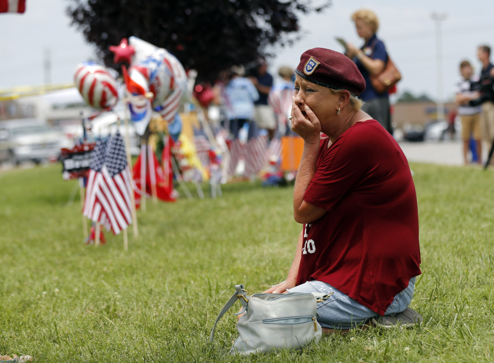 Laurie Norman looks at a makeshift memorial outside a military recruiting center Friday where a gunman opened fire Thursday in Chattanooga, Tenn.