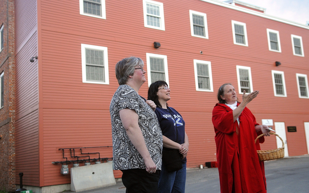 Kelly Henderson, right, describes a building in downtown Hallowell on Wednesday to Michelle Mason-Webber, center, and Lisa Hardman during a Red Cloak Tour of historic and haunted spots in the community.