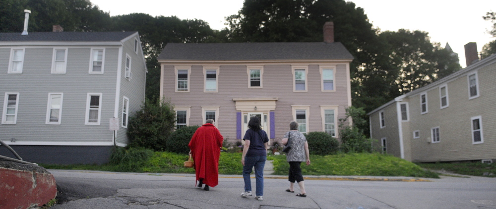 Kelly Henderson, left, leads Michelle Mason-Webber, center, and Lisa Hardman through Hallowell on Wednesday during a Red Cloak Tour of historic and haunted spots in the community.