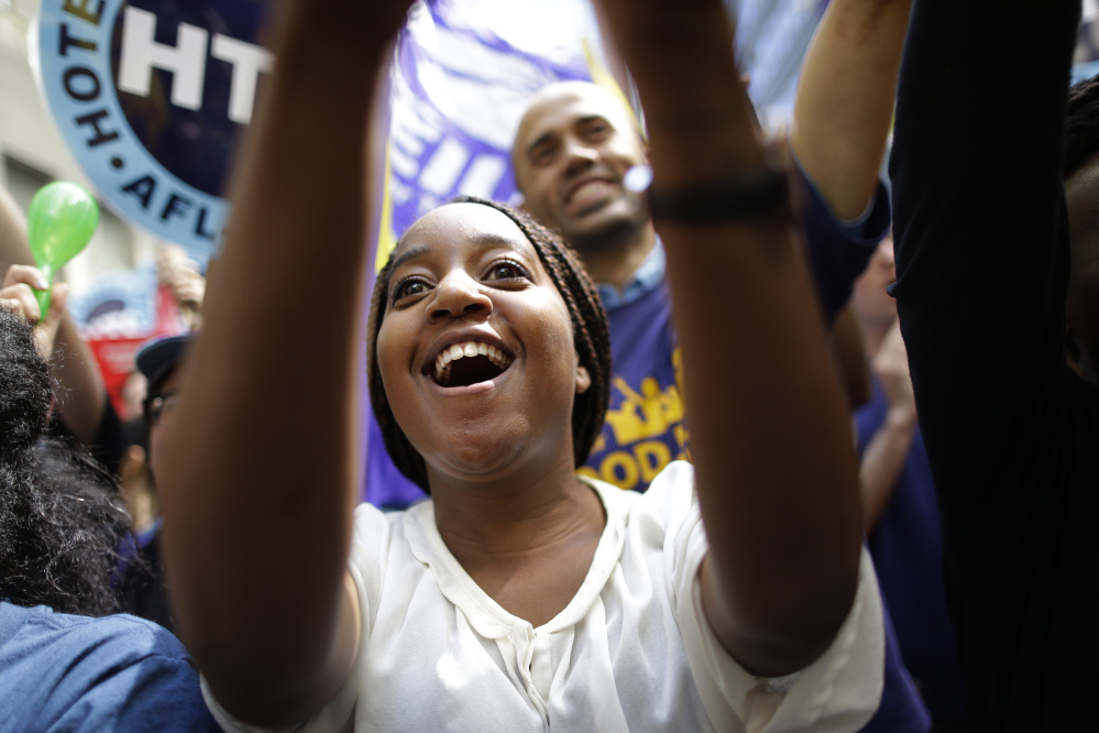 An activist cheers Wednesday after the New York Wage Board endorsed a proposal to set a $15 minimum wage for workers at fast-food restaurants with 30 or more locations.