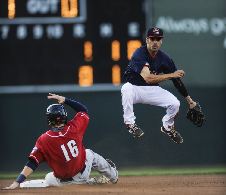 Sea Dogs second baseman Carlos Asuaje leaps to throw the ball to first base for a double play after tagging out New Hampshire’s Shane Opitz on Thursday at Hadlock Field.