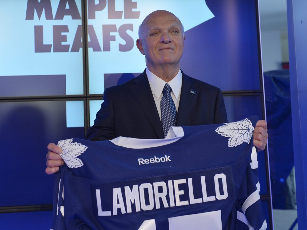 Lou Lamoriello holds up a Maple Leafs jersey at a news conference introducing him as Toronto’s new general manager after 27 years with the Devils.