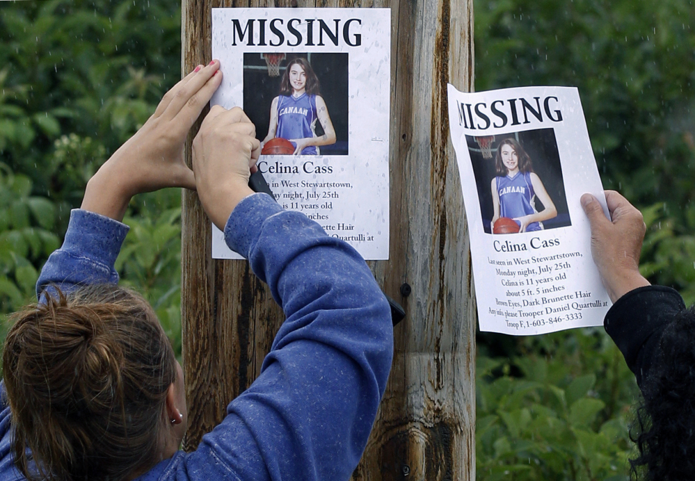 Kaylin Pettit of Stewartstown, N.H., left, and Lori McKearney of Lancaster, N.H., tack missing posters for Celina Cass to a utility pole in Colebrook, N.H., in 2011.