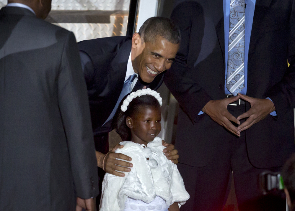 President Obama poses for a picture with Joan Wamaitha, 8, who gave him flowers at the Jomo Kenyatta International Airport in Nairobi, Kenya, on Friday.