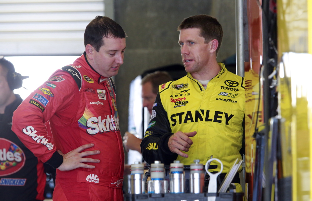 Kyle Busch, left, talks with Carl Edwards during practice for Sunday’s Sprint Cup race at Indianapolis Motor Speedway. Jeff Gordon is the defending champion at a track where he has a record five victories.