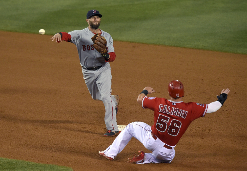 Boston Red Sox second baseman Dustin Pedroia, left, completes a double play against the Los Angeles Angels on July 18. Pedroia was placed on the disabled list Saturday.