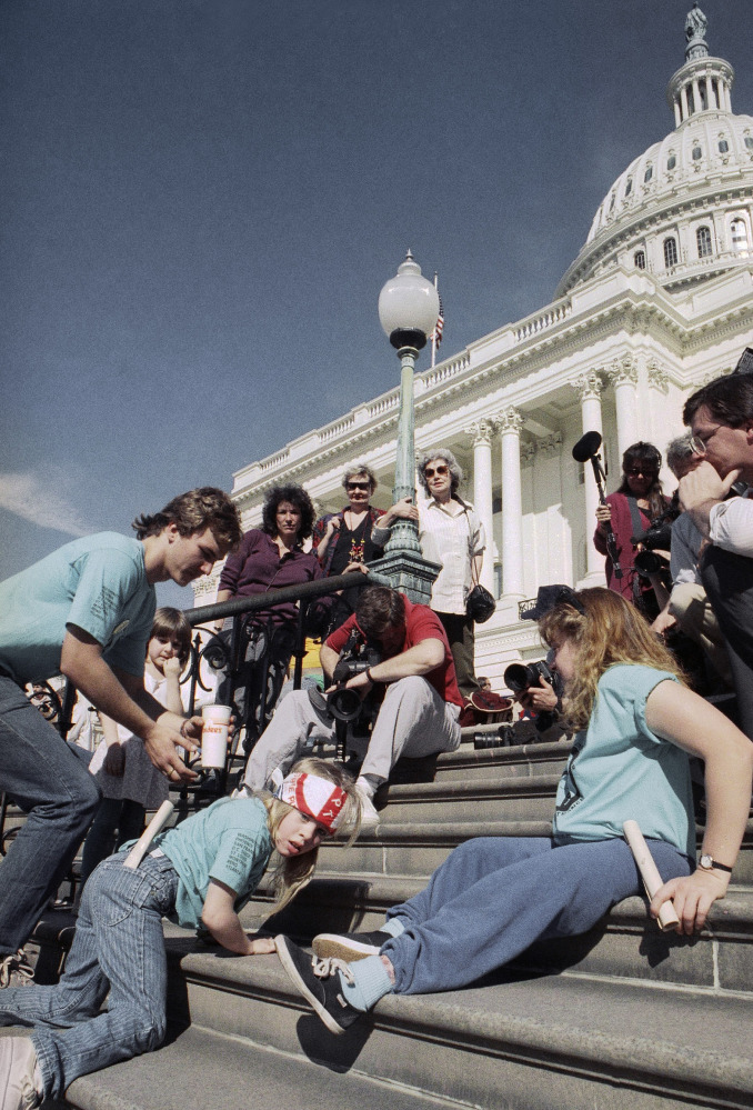 Jennifer Keelan, 8, left, crawls up the steps of the U.S. Capitol in Washington on March 12, 1990, as other people with disabilities follow to draw support for the ADA.