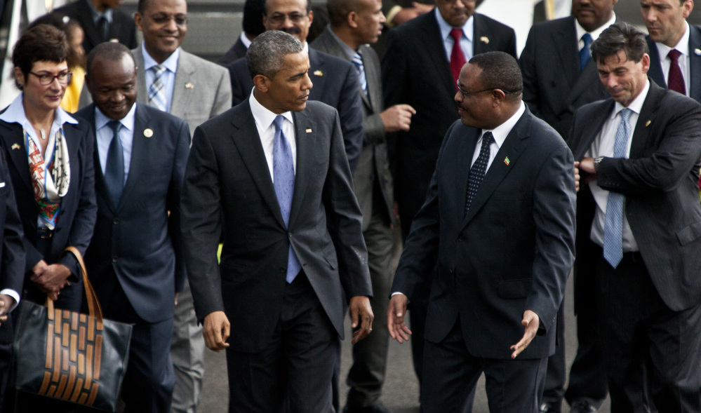 U.S. President Barack Obama, left, walks with Ethiopian prime minister Hailemariam Desalegn, right, at Bole International Airport in  Addis Ababa, Ethiopia. The Associated Press