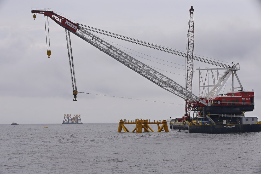 The first foundation jacket installed by Deepwater Wind in the nation’s first offshore wind farm construction project is seen next to a construction crane Monday off Block Island, R.I.