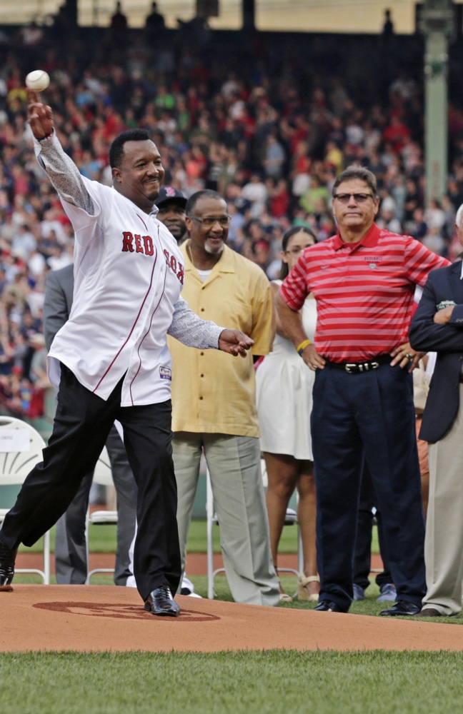 Pedro Martinez throws out the ceremonial first pitch before Tuesday night's game as former Red Sox greats Jim Rice, center, and Carlton Fisk watch.
The Associated Press