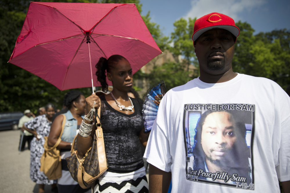 Bill Smith wears a shirt bearing the likeness of Samuel DuBose as he waits in line outside funeral services for DuBose in Cincinnati on Tuesday. DuBose was fatally shot by a University of Cincinnati police officer who stopped him on July 19 for a missing license plate.