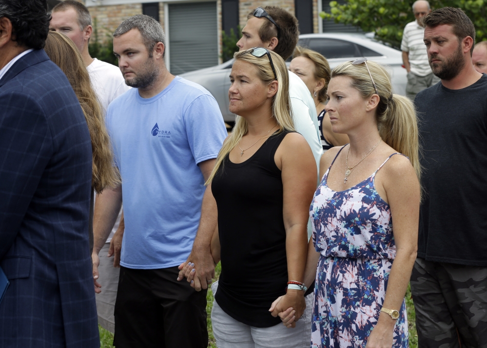 Carly Black, center, mother of Austin Stephanos, one of the missing teenage fishermen, listens as the Coast Guard makes a statement Wednesday.