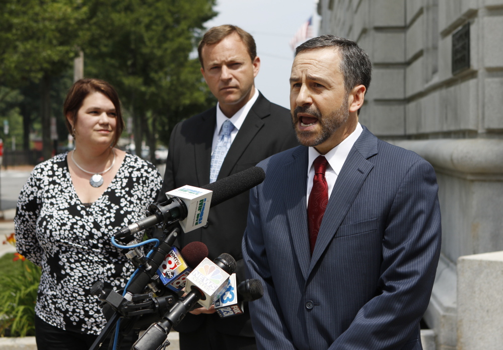 David Webbert, attorney for Maine House Speaker Mark Eves, at rear, speaks to the media outside the federal courthouse in Portland. Webbert said he hopes the court will make Gov. Paul LePage testify under oath in the civil lawsuit filed by Eves. At left is Eves’ wife, Laura.