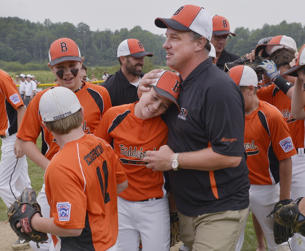 Biddeford Manager Josh Edgerton shares a hug with Cody Albert following the victory that put Biddeford into the New England regionals in Connecticut.