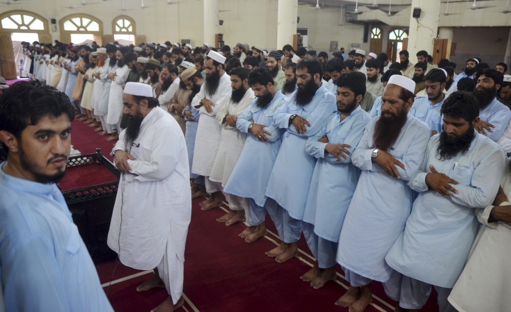 Hafiz Saeed, leader of Pakistan's religious group Jamaatud Dawa, front, leads a funeral prayers for Taliban leader Mullah Mohammad Omar at a mosque in Lahore, Pakistan, Thursday, July 30, 2015. Afghanistan's Taliban on Thursday confirmed the death of Mullah Omar, who led the group's self-styled Islamic emirate in the 1990s, sheltered al-Qaida through the 9/11 attacks and led a 14-year insurgency against U.S. and NATO troops. (AP Photo/Ahmed Ali)