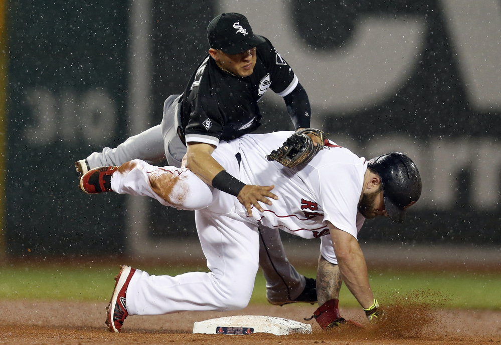 White Sox second baseman Carlos Sanchez falls after making the force-out against Red Sox first baseman Mike Napoli on a fielder’s choice in the fourth inning at Fenway Park on Thursday.