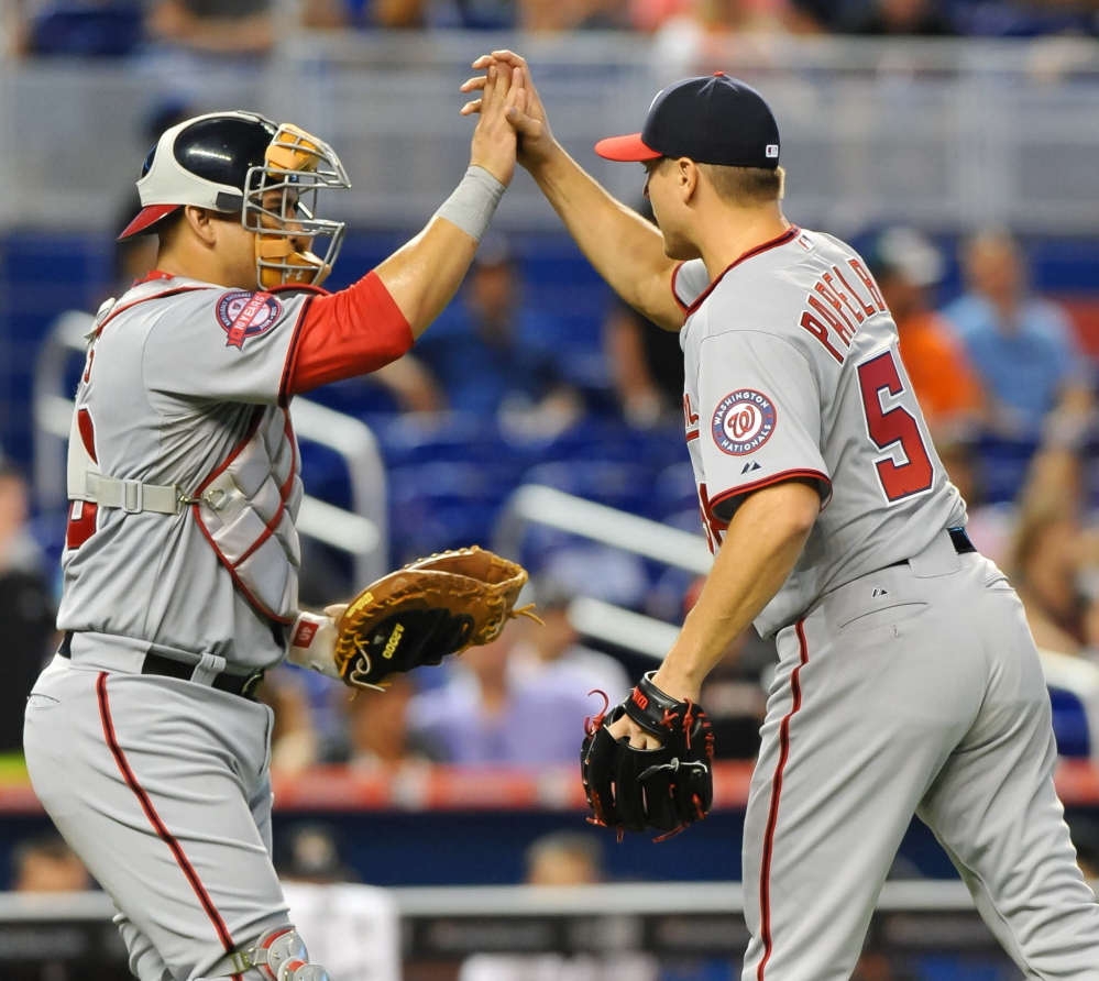 Jonathan Papelbon high-fives catcher Wilson Ramos on Thursday after recording his first save with the Washington Nationals.