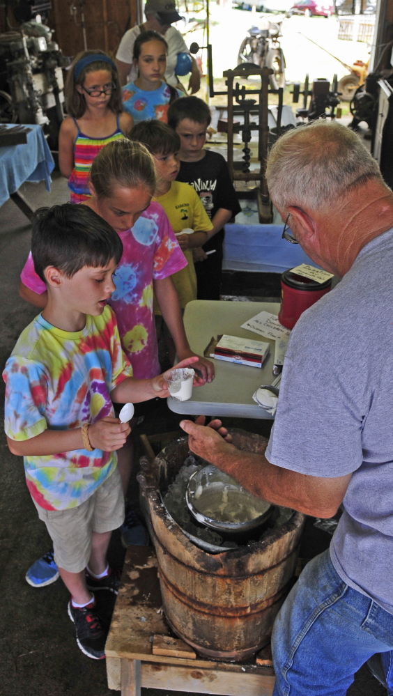 Gary Buzzell of Greene serves the freshly made ice cream. He said he can tell when the batch is ready by taking a turn on the crank. “When it gets so I can barely turn it, it’s pretty well done,” he said.