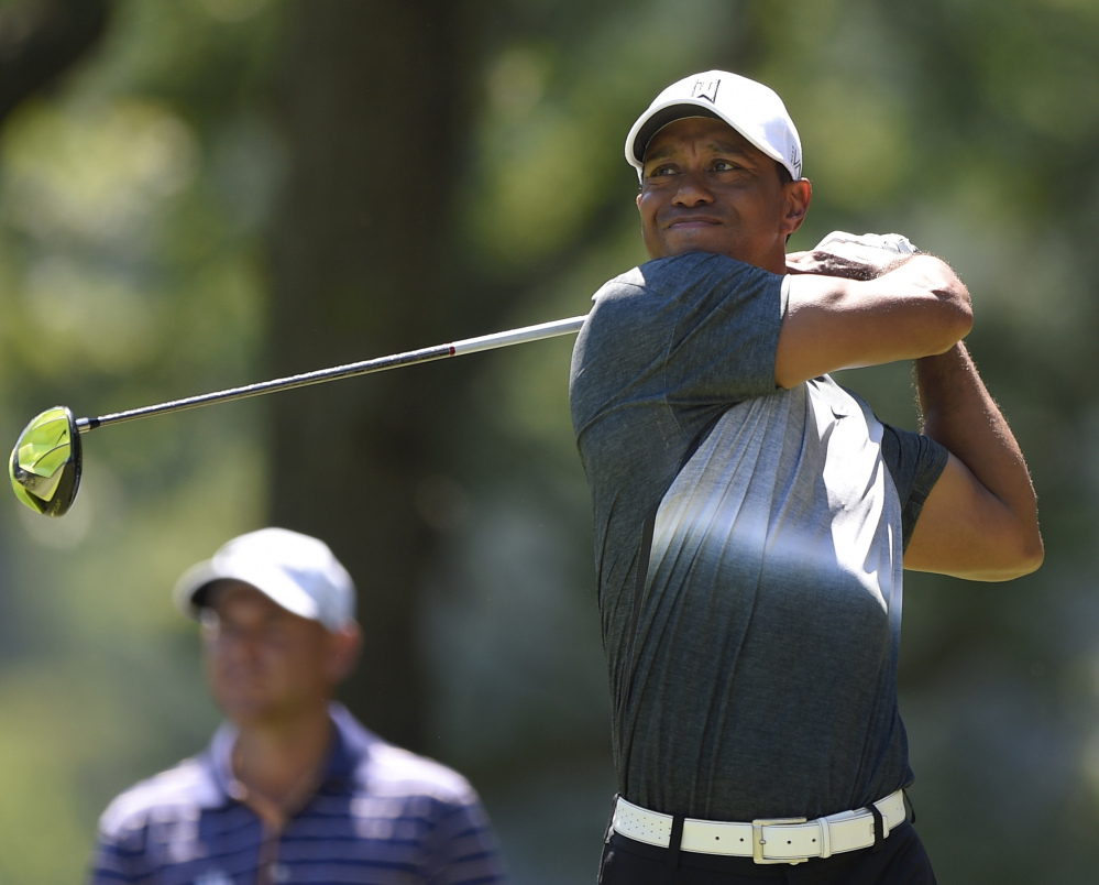 Tiger Woods watches his tee shot soar on the fifth hole of the Quicken Loans National on Friday, in the process of carding a 5-under 66 that left him tied for fifth, three shots behind Ryo Ishikawa.