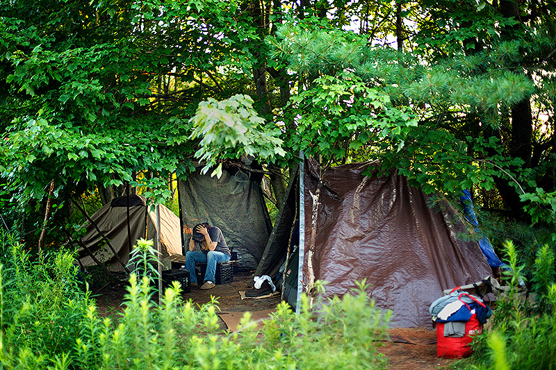 Terry Walters sits in a homeless encampment in a wooded area on the outskirts of Portland in July. A new federal report says the number of homeless Mainers declined in 2015, but the state has twice as many unsheltered homeless people as it did in 2010.