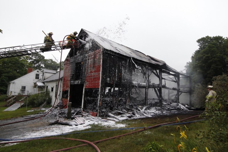 Firefighters douse a barn fire at 3000 Milton Mills Road in Acton. Jill Brady/Staff Photographer