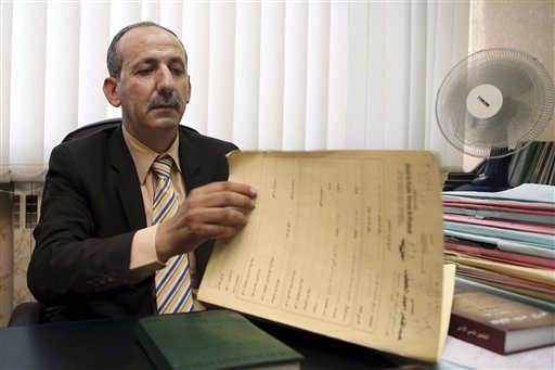 Abed al-Kader Ahmad al-Khateeb, a lawyer of Asaad Ibrahim Asaad Haj Ali, an uncle of the Chattanooga attacker, Muhammad Youssef Abdulazeez, goes over papers during an interview with The Associated Press in Amman, Jordan, Tuesday. The uncle of Abdulazeez, who killed four Marines and a sailor in attacks on Tennessee military sites last week, has been in custody in Jordan since a day after the attack, the lawyer said Tuesday. The Associated Press