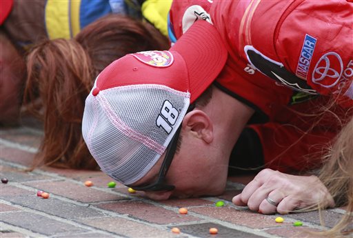 Kyle Busch kisses the bricks on the start/finish line after winning the NASCAR Brickyard 400 at Indianapolis Motor Speedway in Indianapolis on Sunday. The Associated Press