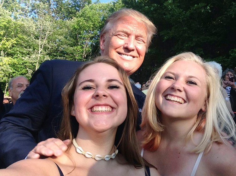 Republican presidential hopeful Donald Trump poses for a photo with Emma Nozell, left, and her sister Addy Nozell in Laconia, N.H. Emma Nozell via AP