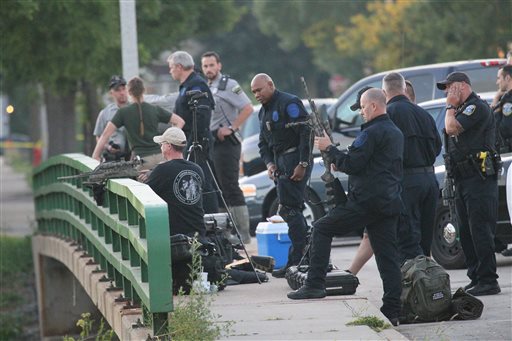 Police gather to contain a reported lion in Milwaukee on Monday. Officers armed with rifles and Department of Natural Resources staff carrying tranquilizer guns searched a ravine and surrounding neighborhood for an elusive lion-like animal after police were among those who spotted the big cat. Michael Sears/Milwaukee Journal Sentinel via AP