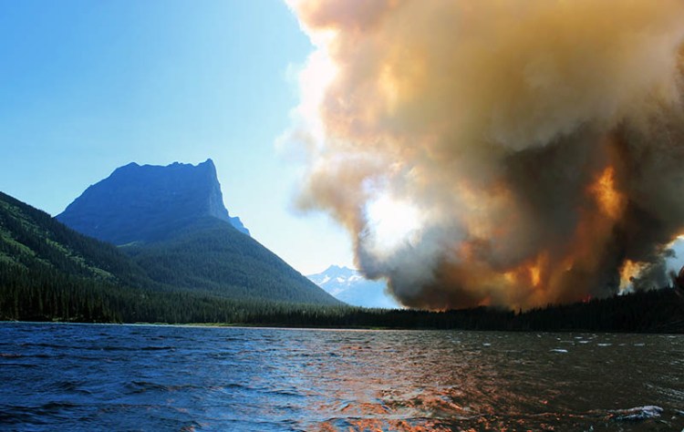 Smoke from the Reynolds Creek wildfire rises above the landscape at St. Mary Lake in Glacier National Park, Mont.