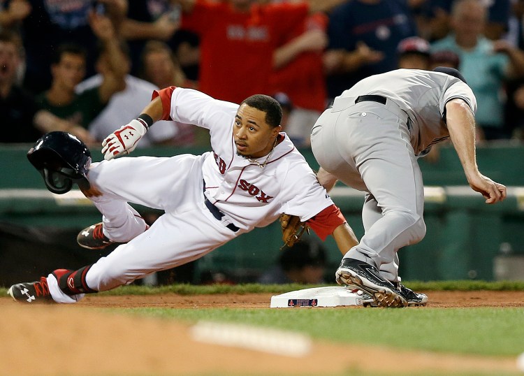 Boston Red Sox's Mookie Betts (50) is safe with a triple as New York Yankees' Chase Headley comes in late with the tag during the seventh inning of a baseball game in Boston, Saturday. The Associated Press