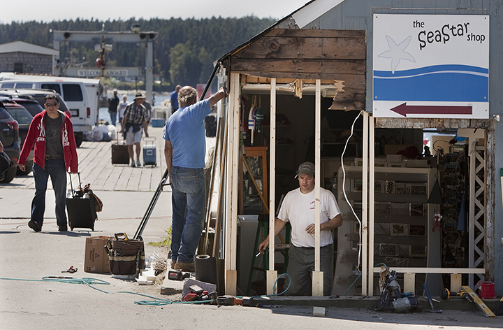 Tim Harris and  Joseph Richardi of Port Clyde repair the damage to a shop at the scene of a fatal auto pedestrian accident at the wharf in Port Clyde in this 2013 file photo. Carl D. Walsh/Staff Photographer 