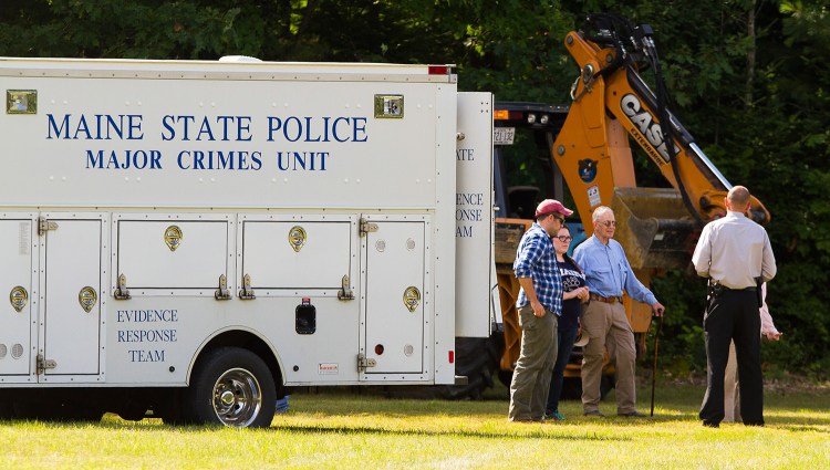 Investigators confer Sunday near the state police major crime unit truck at the search scene for Kimberly Moreau near Route 108 in Canton. A back hoe was among the equipment used to dig for evidence in case. 
