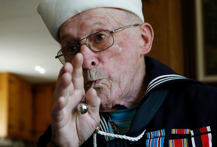 WWII veteran Conrad Lebourdais demonstrates whistle signals he used during his time on board a ship in the Pacific Theater in World War II. Joel Page/Staff Photographer