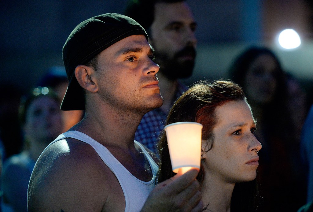 Scott McCullough and Hanna Marchetti of Portland stand together Monday evening during a candlelight vigil in Monument Square that was part of International Overdose Awareness Day.
