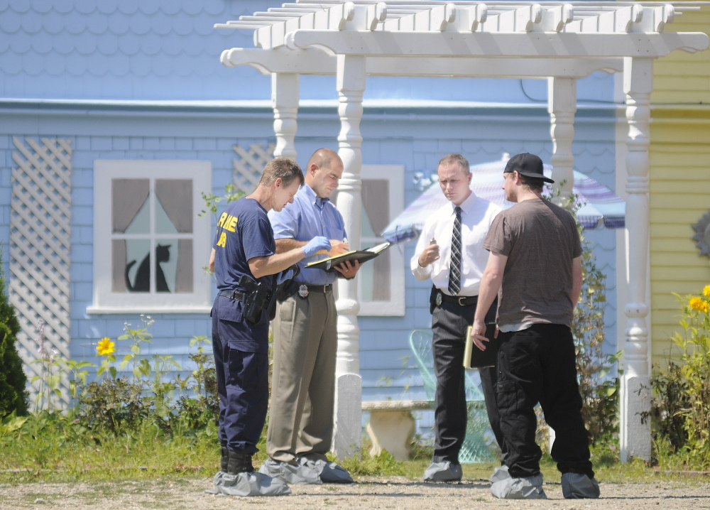 Maine State Police detectives interview a former resident of a boarding house in East Pittston about a stabbing that occurred on Saturday.