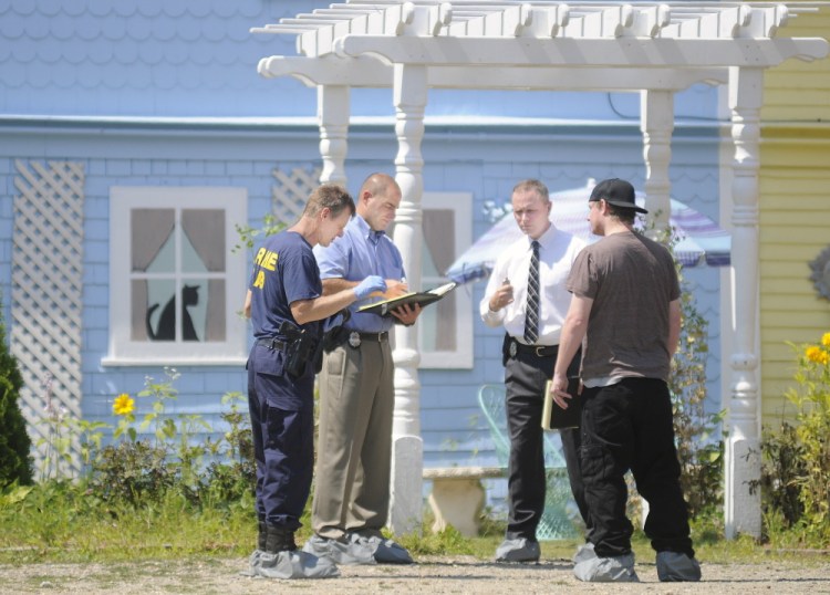 Maine State Police detectives interview a former resident of a boarding house in East Pittston about a stabbing that occurred on Saturday. Staff photo by Andy Molloy/Kennebec Journal